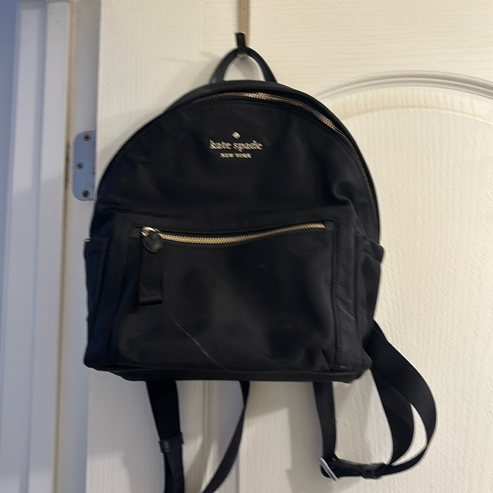 black kate spade mini backpack with gold detail is a tiny scratch on the front